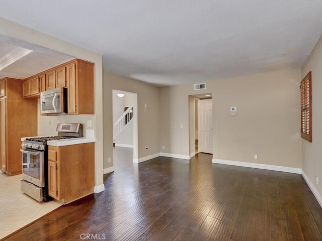 kitchen with light hardwood / wood-style floors and appliances with stainless steel finishes