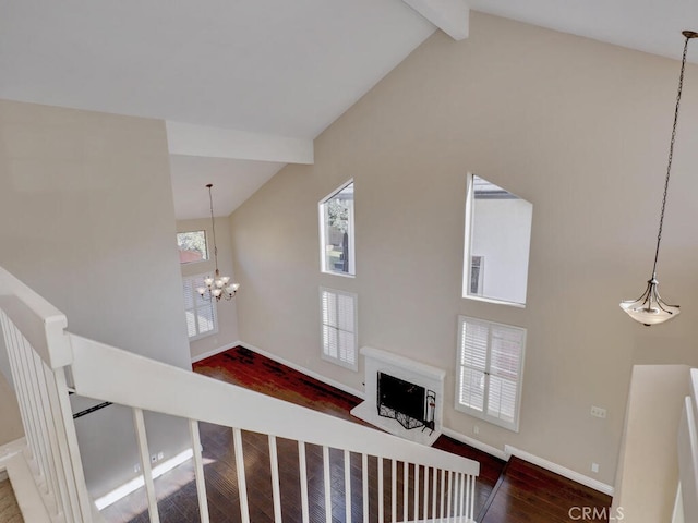 stairway featuring high vaulted ceiling, hardwood / wood-style flooring, beamed ceiling, and an inviting chandelier