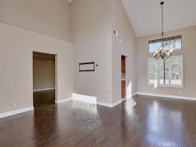 spare room with high vaulted ceiling, dark hardwood / wood-style flooring, and an inviting chandelier