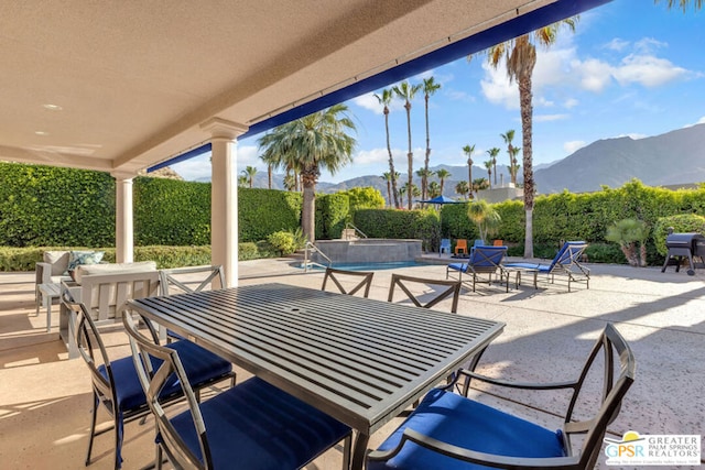 view of patio / terrace featuring a fenced in pool, a grill, and a mountain view