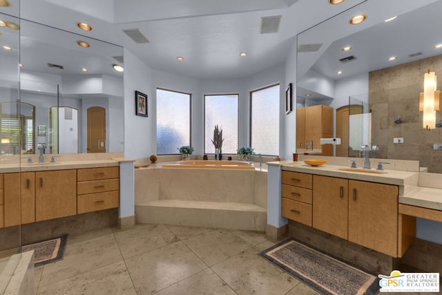 bathroom featuring plus walk in shower, vanity, and tile patterned flooring