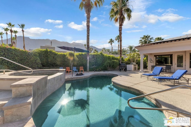 view of swimming pool with a mountain view and a patio