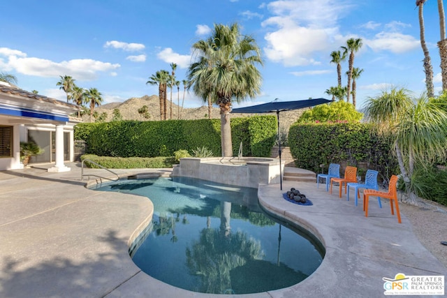 view of swimming pool with a mountain view and a patio area