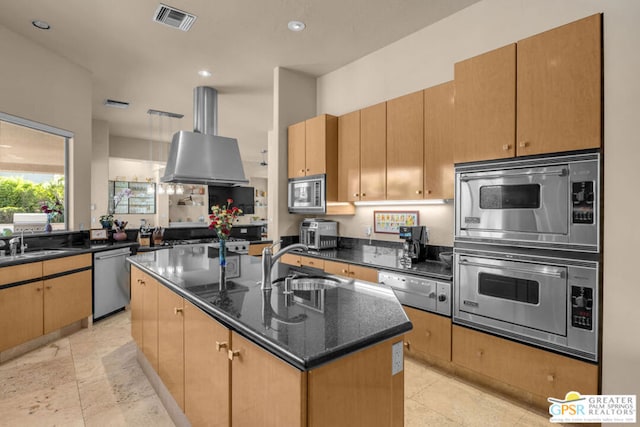 kitchen with stainless steel appliances, island range hood, a kitchen island with sink, sink, and dark stone countertops