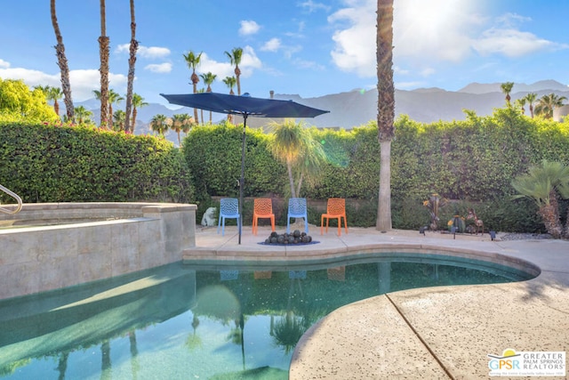 view of swimming pool with a mountain view and a patio