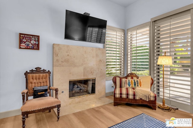 living area featuring a tile fireplace and hardwood / wood-style floors