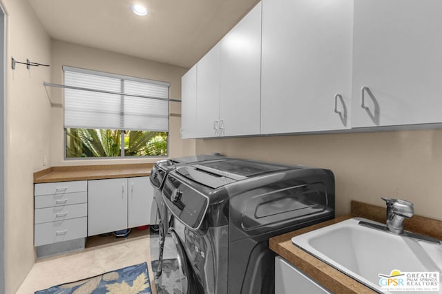 clothes washing area with sink, light tile patterned floors, cabinets, and independent washer and dryer