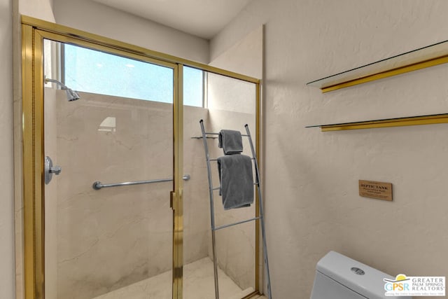 bathroom with toilet and a shower with door