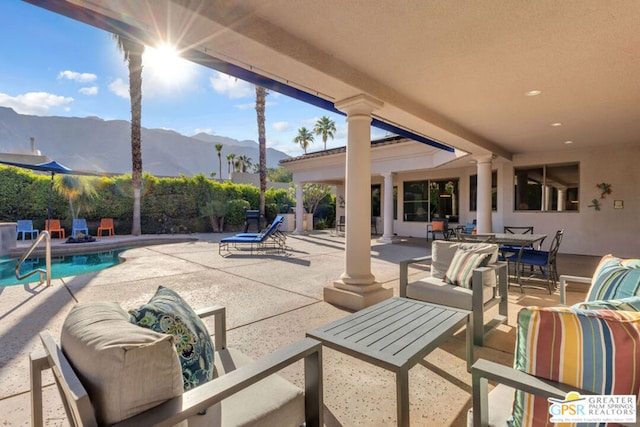 view of patio featuring a mountain view, an outdoor hangout area, and a fenced in pool