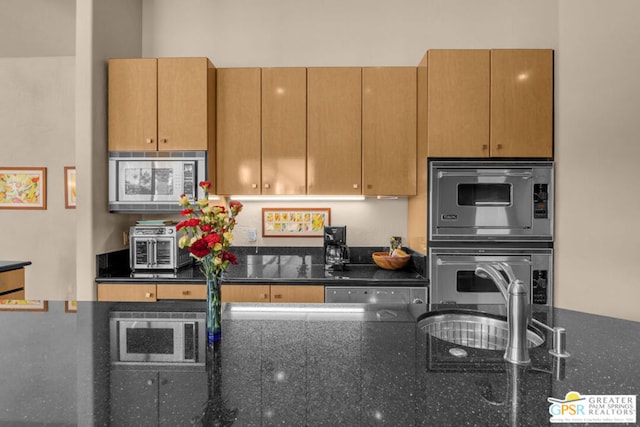 kitchen featuring dark stone countertops and appliances with stainless steel finishes