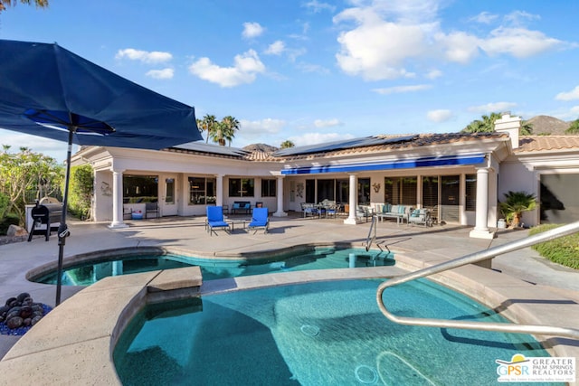 view of swimming pool featuring a patio area and an in ground hot tub