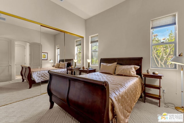 carpeted bedroom with a closet and multiple windows