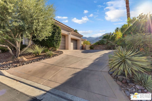 view of front of home with a mountain view and a garage