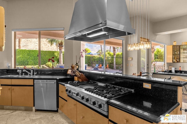 kitchen with appliances with stainless steel finishes, light brown cabinets, plenty of natural light, and wall chimney range hood