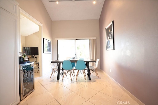 dining room with bar area, light tile patterned flooring, wine cooler, and vaulted ceiling