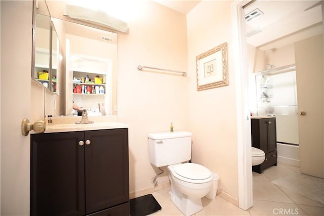 bathroom featuring tile patterned flooring, vanity, a shower with door, and toilet