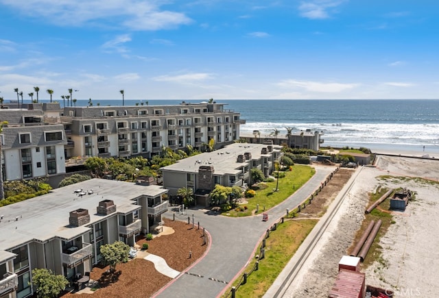 birds eye view of property with a water view and a beach view