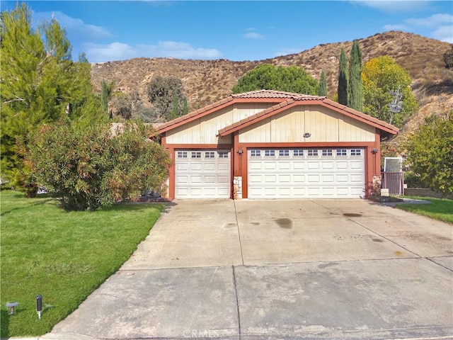 view of front of house with a front lawn, a garage, and a mountain view