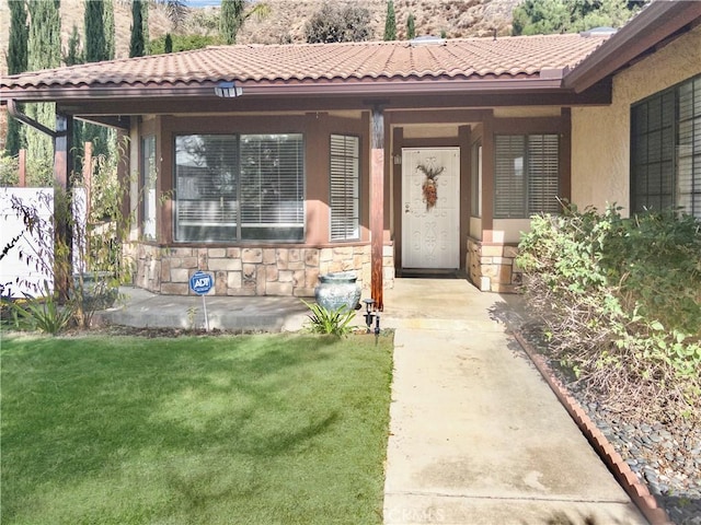 view of exterior entry with a yard