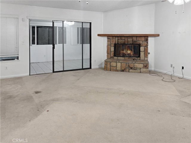 unfurnished living room featuring ceiling fan, carpet, and a fireplace