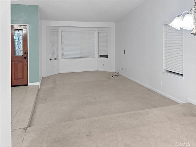 interior space with light colored carpet and a notable chandelier