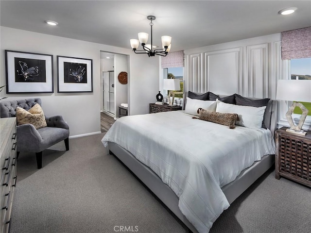 carpeted bedroom featuring ensuite bath and a notable chandelier