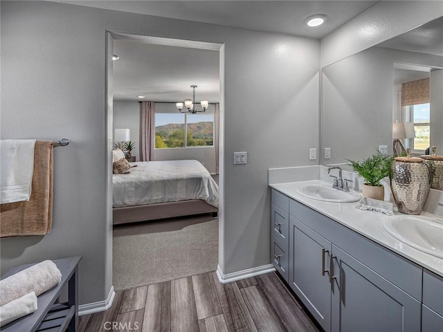 bathroom featuring a chandelier, hardwood / wood-style floors, vanity, and a wealth of natural light