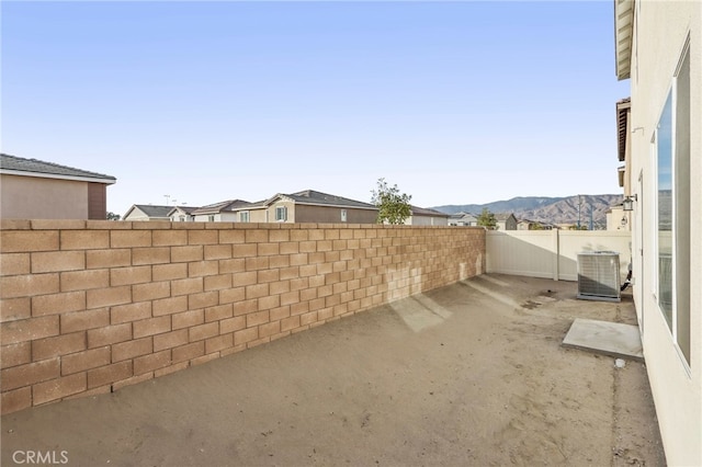 view of yard with a mountain view, a patio, and central air condition unit