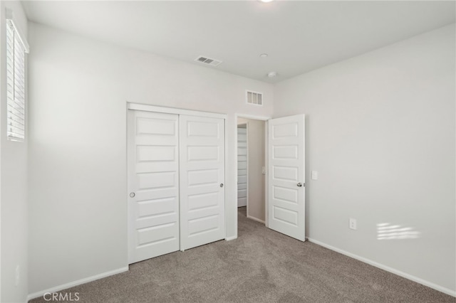 unfurnished bedroom with carpet floors and a closet