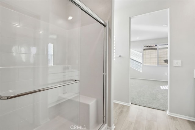 bathroom featuring hardwood / wood-style flooring and walk in shower