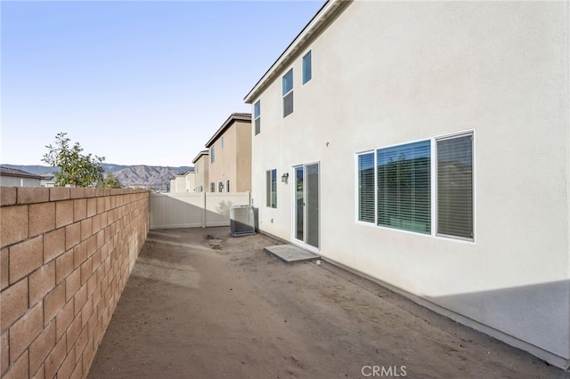 view of side of property featuring central AC and a mountain view