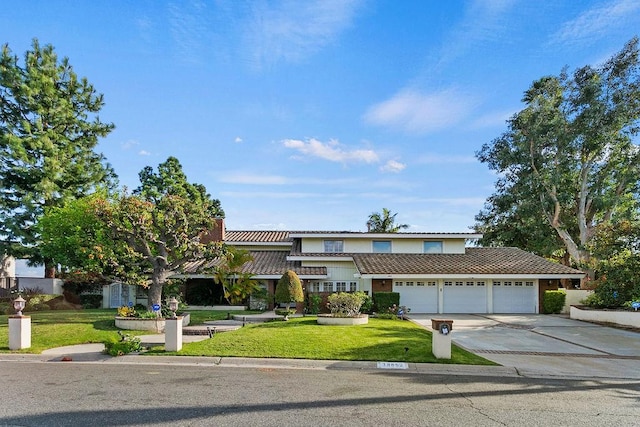 view of front of property featuring a front yard and a garage