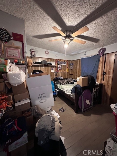 bedroom with ceiling fan, a textured ceiling, and hardwood / wood-style flooring