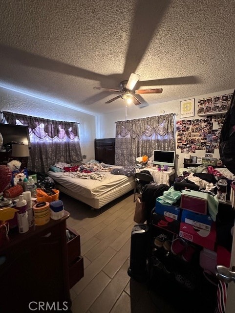 bedroom featuring ceiling fan, a textured ceiling, and light hardwood / wood-style flooring