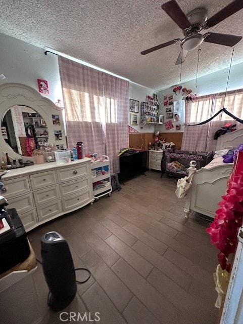 bedroom with a textured ceiling, hardwood / wood-style flooring, and ceiling fan