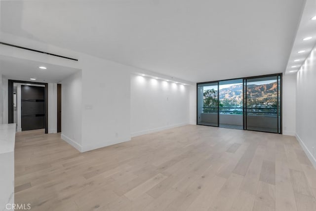 unfurnished room featuring light wood-type flooring and floor to ceiling windows