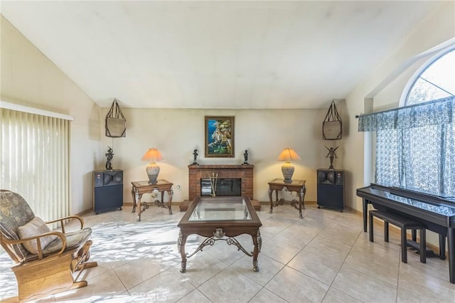 living area featuring a fireplace, light tile patterned floors, and lofted ceiling