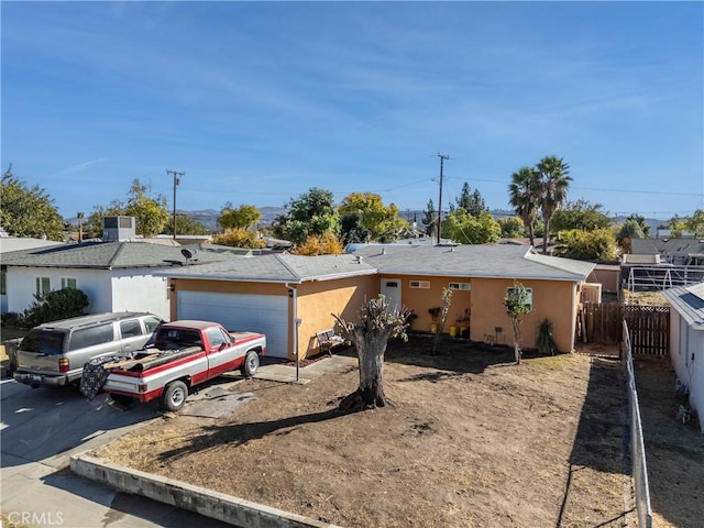 ranch-style home with central air condition unit and a garage