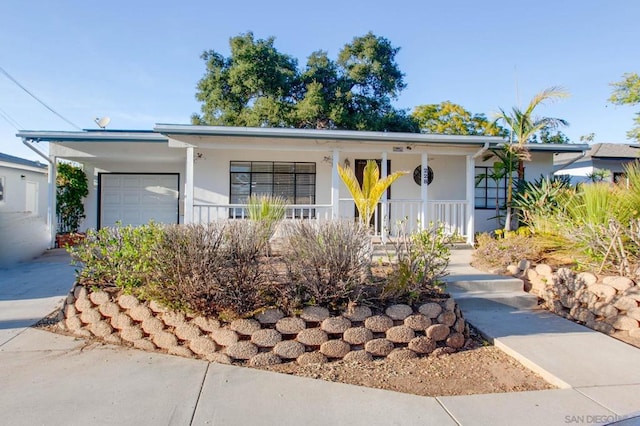 single story home featuring a garage and a porch