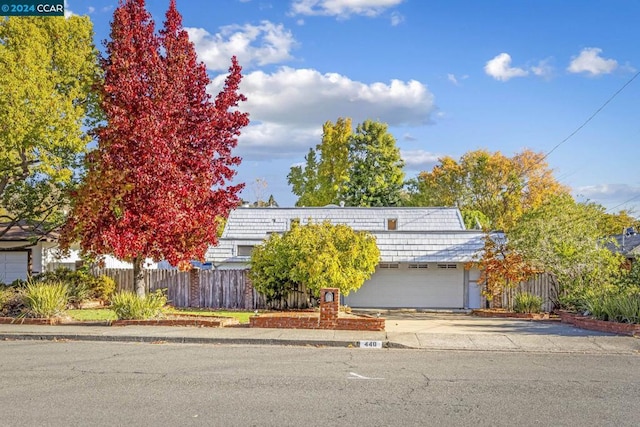 view of property hidden behind natural elements with a garage