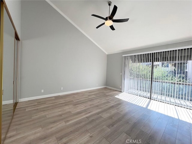 unfurnished room featuring crown molding, light hardwood / wood-style flooring, ceiling fan, and lofted ceiling