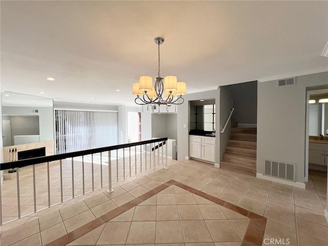 hallway with light tile patterned floors and an inviting chandelier