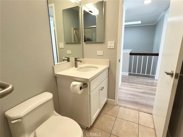 bathroom featuring vanity, toilet, wood-type flooring, and crown molding