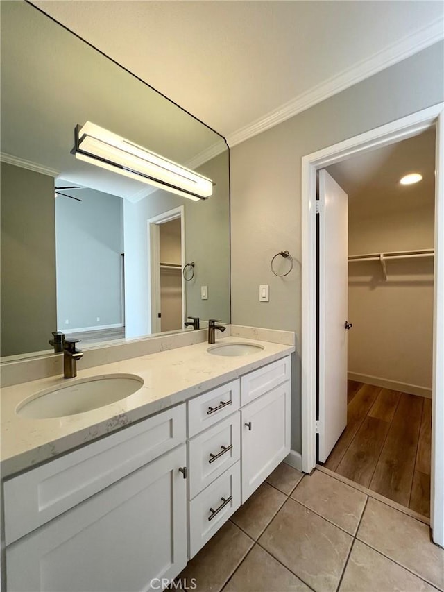 bathroom with tile patterned flooring, vanity, ceiling fan, and crown molding