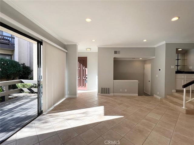 tiled spare room featuring crown molding