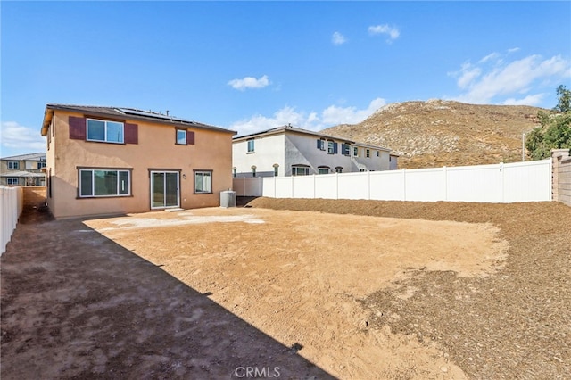 back of house featuring central AC unit and a mountain view