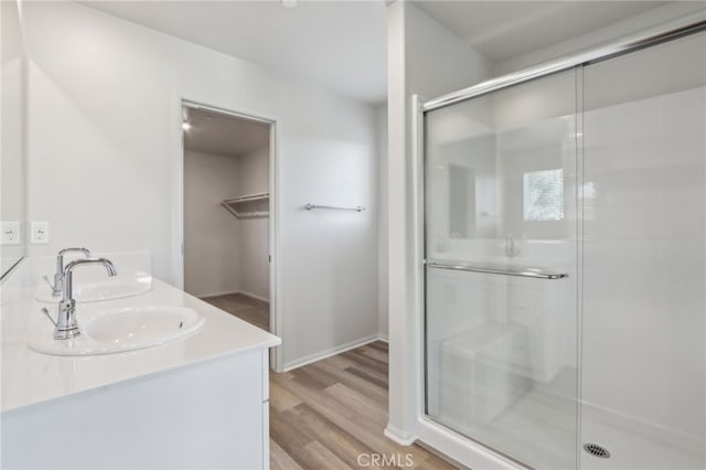 bathroom featuring hardwood / wood-style flooring, vanity, and walk in shower