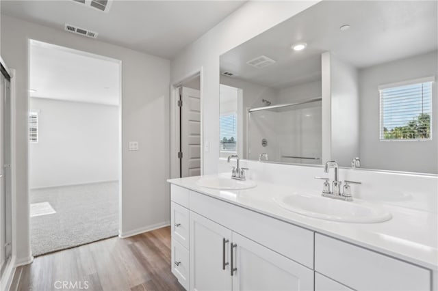 bathroom featuring walk in shower, vanity, and hardwood / wood-style floors