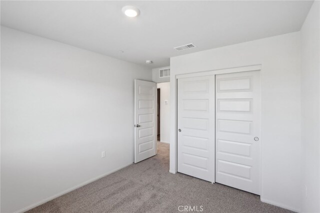 unfurnished bedroom with a closet and light carpet