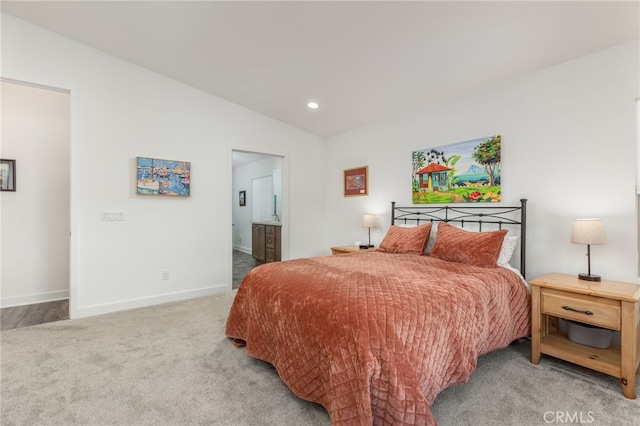 carpeted bedroom with lofted ceiling and ensuite bath